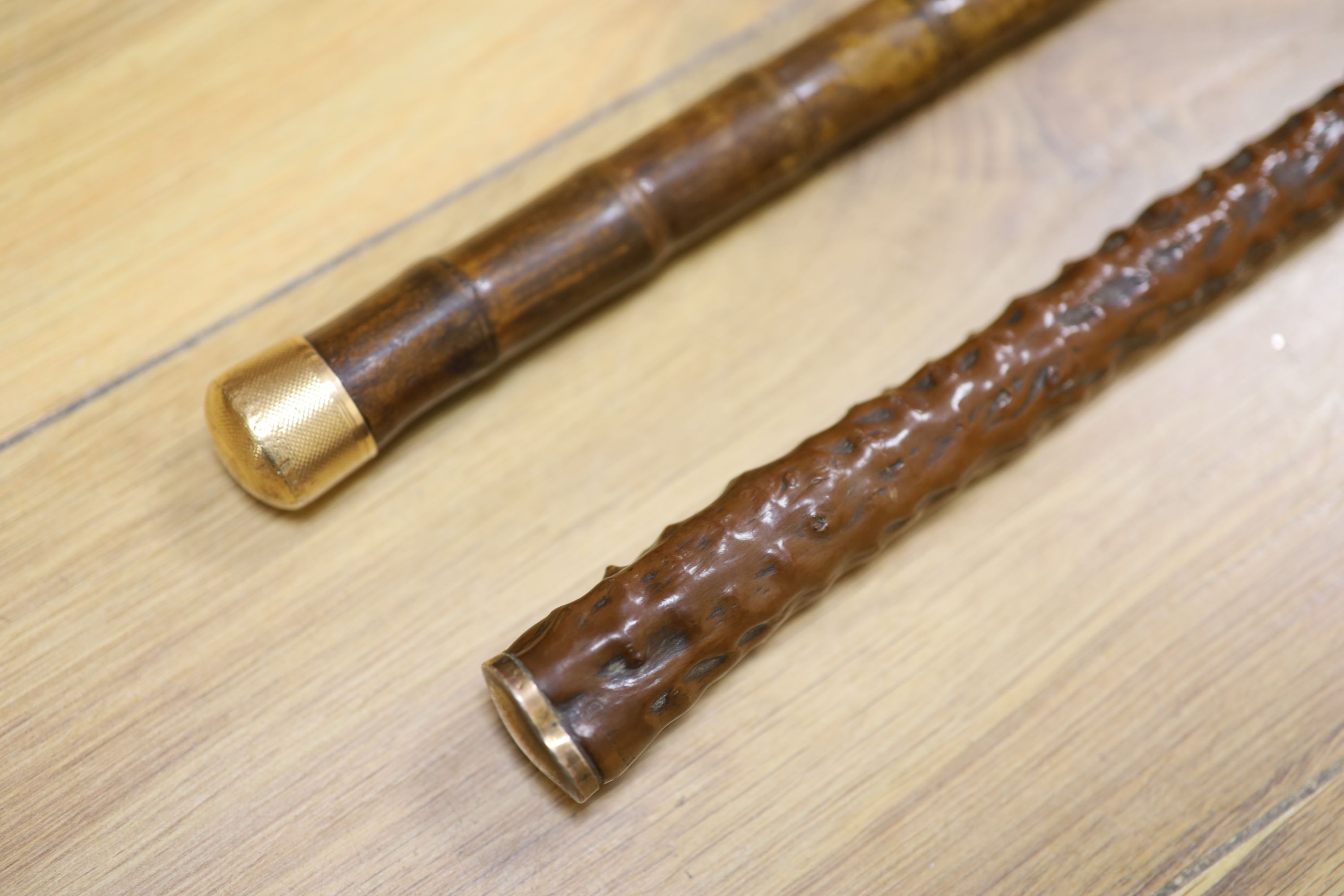 A yellow metal mounted bamboo cane and a gilt metal mounted cane